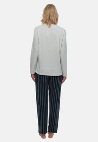 Lichtgrijze longsleeve top gecombineerd met marineblauwe gestreepte broek, voorzien van verticale witte strepen, gemaakt van zachte stof, ontworpen voor comfort.