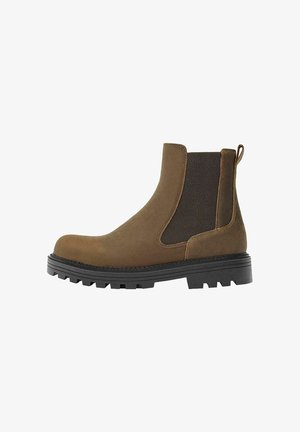 Stivaletto Chelsea in camoscio marrone con pannello laterale elastico nero, suola spessa nera carrarmato e linguetta posteriore.