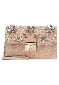 Borsa in pizzo rosa decorata con ornamenti floreali, perle e gemme. Presenta una chiusura dorata e una tracolla a catena staccabile.