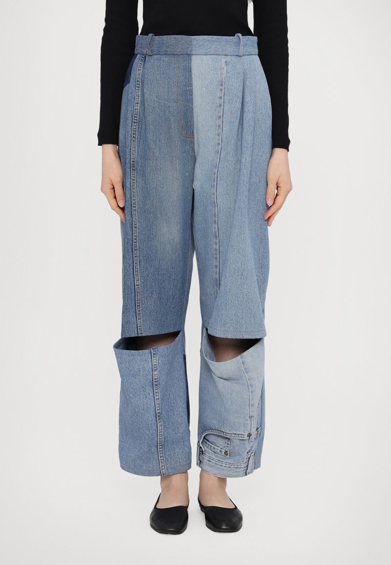 Farkkuhousut, joissa on ainutlaatuinen muotoilu, erottuvia sinisen sävyjä, leveä lahkeensuukuvio ja avoimet taskut alaosassa.