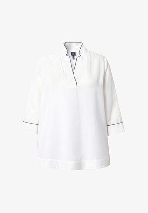 Tunique blanche avec col montant, manches trois-quarts et passepoil bleu marine le long du col et des poignets. Texture de tissu lisse.