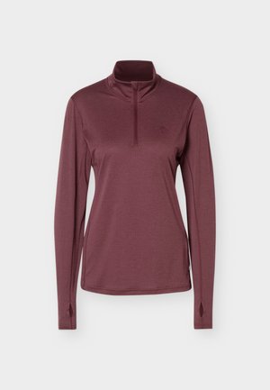 Dugi rukav, bordo pulover s četvrtastim patentnim zatvaračem, rupama za palčeve na manšetama, visokim ovratnikom i uskim krojem.