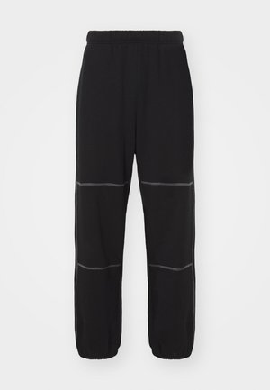 Pantalones de chándal negros con cintura elástica, que presentan costuras y puños en gris contrastante. El diseño incluye dos costuras horizontales en cada pierna.