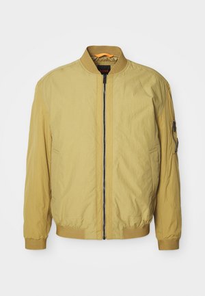 Geltonas bombonešio tipo švarkas su užtrauktuku, margintu apykakle ir rankovėmis, šoninėmis kišenėmis bei papildoma kišene rankovėje. Sklandus paviršius.