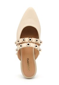 Mules ouverts beiges avec un design pointu, dotés de deux brides ornées de clous métalliques brillants. Texture en cuir lisse et style minimaliste.