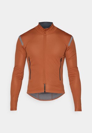 Dlhoprstá cyklistická bunda v spálenej oranžovej farbe, s polovičným zipsom vpredu, reflexnými sivými akcentmi a dvoma zipsovými bočnými vreckami.