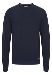 Pull-over en maille bleu marine avec manches longues, col rond, poignets et ourlet côtelés, avec une petite étiquette de marque au bas.