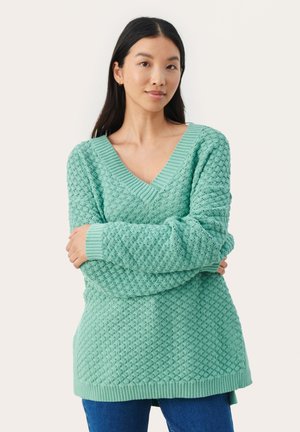 Pulover tricotat de culoare verde mentă, cu guler în V și un model texturat. Prezintă manșete și tiv ribbate. Mâneci lungi și croială lejeră.