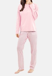 Ljust rosa långärmad topp i kombination med randiga pyjamasbyxor med rosa, blå och vita vertikala linjer; bomullstyg, avslappnad passform.