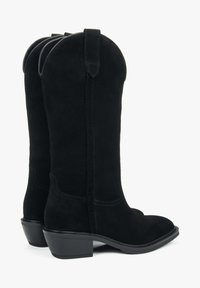 Czarne zamszowe kowbojki z ostrym noskiem, średnim blokowym obcasem i pionowymi szwami po bokach.