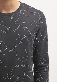 Black long-sleeve shirt featuring white mathematical diagrams and equations printed across the fabric, with a crew neckline and soft texture.