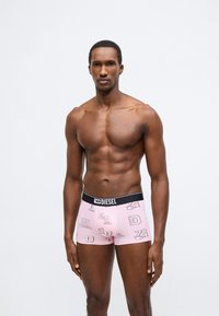 Rózsaszín csíkos boxeralsó fekete Diesel márkájú derékpánttal, fehér és piros grafikákkal és számokkal díszítve. Sima szövet textúra.