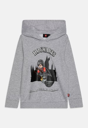 Grauer Kapuzenpullover mit LEGO-Zauberer, der auf einem Besen vor der Silhouette von Hogwarts fliegt, beschriftet mit "Hogwarts Schule für Hexerei und Zauberei."