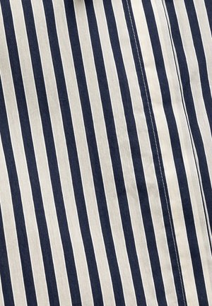 Gestreifter Stoff mit abwechselnd navyblauen und cremefarbenen vertikalen Streifen, glatte Textur, mit sichtbaren Nähten entlang der Nähte.