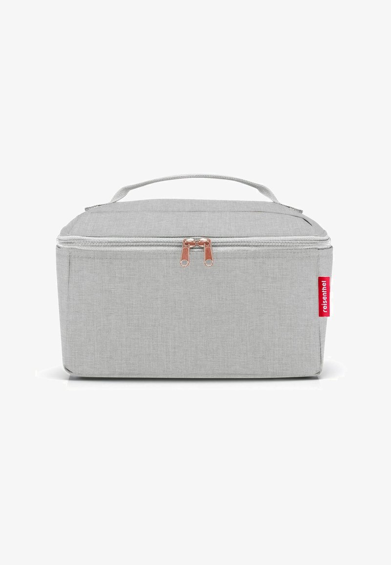Grijze stoffen reiskoffer met ritssluiting, vlakke bovenkant, handvat en roségouden hardware accenten. Opvallende rode logo-tag aan één kant.