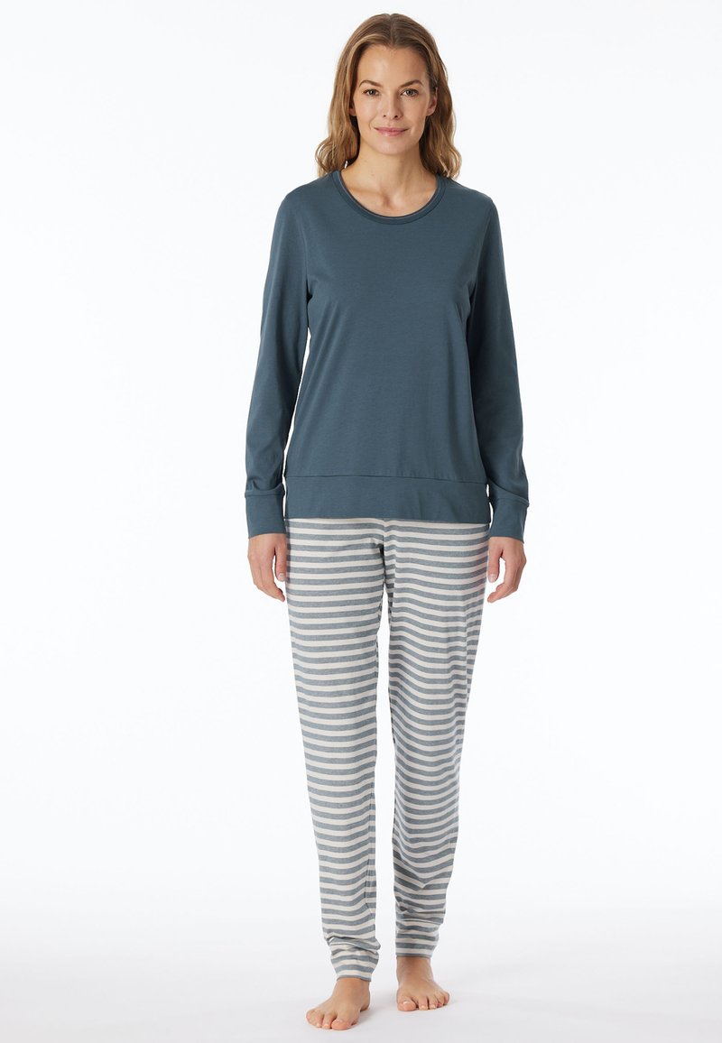 Maglietta azzurro chiaro a maniche lunghe abbinata a pantaloni da pigiama morbidi a righe grigie e bianche. Entrambi i capi presentano una vestibilità comoda e una texture liscia.
