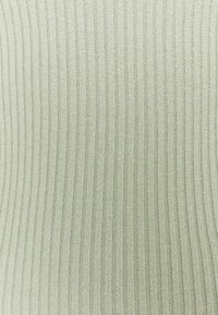 Tejido de punto acanalado en un suave y sutil color verde. Las rayas verticales crean textura, con un acabado suave en todo el material.