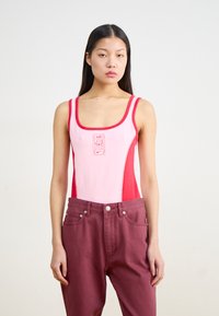 Roosa ja punane üheosaline ujumistrikoo spordikujundusega, millel on ümar kaelus ja logo detail rinnal. Sobitatud burgundy pükstega.