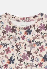 Kurzarm-Blusene mit floralen Mustern auf cremefarbenem Hintergrund. Verfügt über lila, blaue und orangefarbene Blumenmuster, einen runden Ausschnitt und eine weiche Textur.