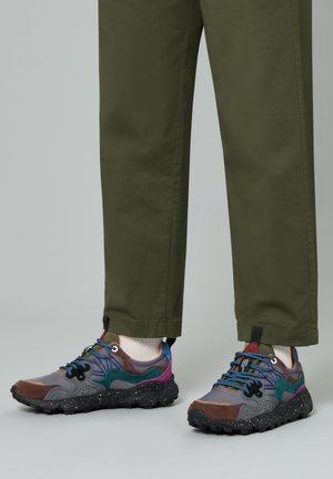 Bunte Sneakers mit einer Mischung aus Grau, Braun und Türkisakzenten, ausgestattet mit einer strukturierten Sohle, kontrastierenden Schnürsenkeln und einer gesprenkelten Zwischensohle.