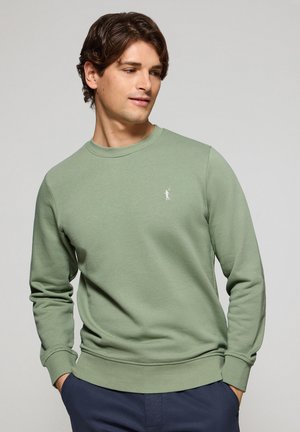 Grøn sweatshirts lavet af blødt bomuldsstof, med rund halsudskæring, ribbede manchetter og et lille hvidt logo på brystet.