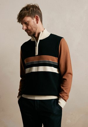 Sweter dzianinowy z ćwierć zamkiem, w poziome paski w kolorach czarnym, brązowym i kremowym. Rybkowane mankiety i dolny brzeg dodają faktury.