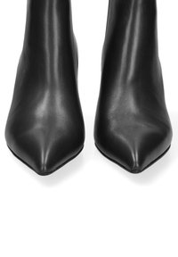 Stivali alla caviglia in pelle nera con punta affusolata, dal design elegante e dalla texture liscia, caratterizzati da un gambale aderente e senza hardware visibile.