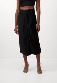 Culottes en denim noir avec une taille haute, deux boutons à l'avant et une longueur en dessous du genou. Texture lisse avec une coupe droite et des poches latérales.