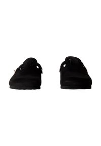 Zoccoli in suede nero con punta arrotondata, tagli laterali e suola in gomma testurizzata. Presentano un design minimalista senza decorazioni visibili.