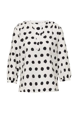 Biała bluzka w czarne kropki, okrągły dekolt i rękawy 3/4 w formie bufek. Lekki materiał o lekko fakturowanym wykończeniu.