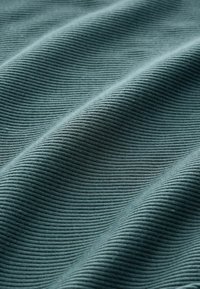 Texturovaná látka v tlumené tyrkysové barvě, s proužkovaným vzorem, který vytváří hloubku a dimenzi se soft, vlnícími se záhyby.