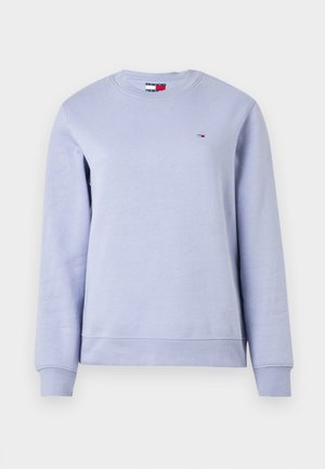 Jasnofioletowa bluza z okrągłym dekoltem i długimi rękawami. Posiada ściągacze na mankietach i u dołu oraz małe logo na górnej części piersi. Miękka w dotyku.