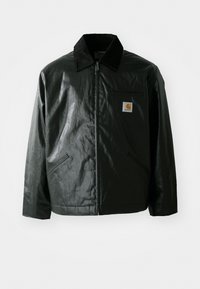 Giacca nera con zip realizzata in materiale liscio e lucido. Presenta un colletto in corduroy, due tasche frontali e una piccola patch con logo sul petto.