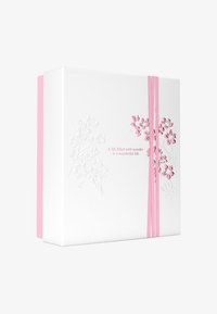 Hvit boks med preget blomstermønster, med rosa blomster. Sikker med to rosa bånd, ett på hver side, med tekst i rosa.