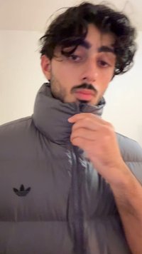 Γκρι αμάνικο καπιτονέ μπουφάν με ψηλό γιακά και κλείσιμο με φερμουάρ. Διαθέτει μαύρο λογότυπο Adidas στο αριστερό στήθος. Λείο, γυαλιστερό υλικό με σχεδιασμό με επένδυση.