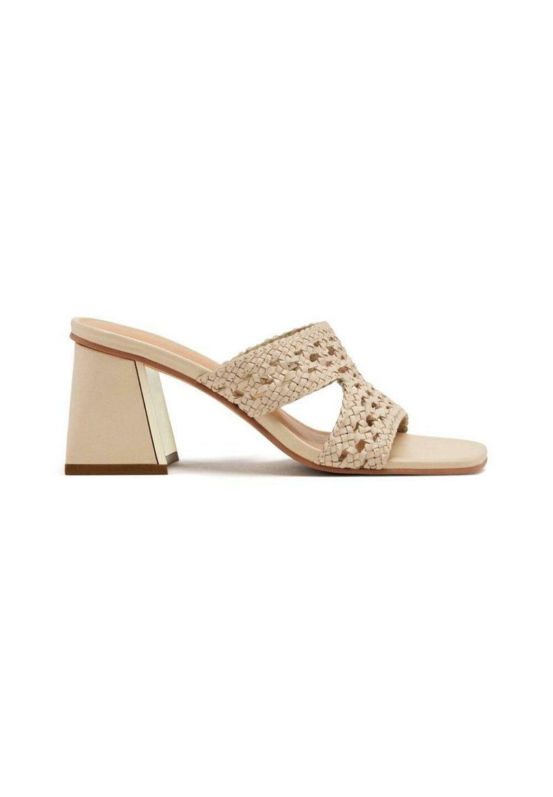 Sandalias de tacón trenzadas en color beige con tacón cuadrado. La parte superior presenta un diseño entrelazado y una plantilla suave para mayor comodidad.