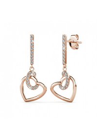 Orecchini a forma di cuore in oro rosa con un design pendente. Presentano una barra incastonata di pietre scintillanti e un dettaglio a cuore intrecciato.
