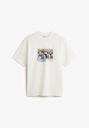 Weißes Baumwoll-T-Shirt mit einem zentralen Grafikdruck von Sprühdosen in Schwarz und Weiß, mit bunten Akzenten, einschließlich Textelementen.