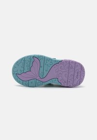Suela de zapato de goma morada y verde azulado que presenta un diseño de cola de sirena, patrones florales y agarres texturizados para tracción.
