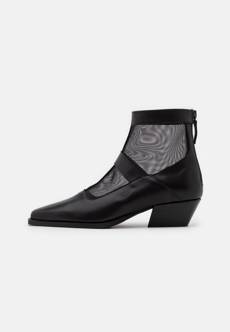 Les bottines noires présentent une tige en cuir élégante avec des panneaux en maille. Elles sont dotées d'un bout pointu et d'un talon carré de hauteur moyenne, complétant ainsi un design moderne.