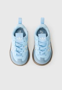 Baskets de sport bleu clair avec dessus synthétique texturé, fermeture à lacets et semelle en caoutchouc. Présente trois rayures blanches et une languette pour un enfilage facile.
