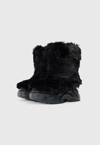 Botas negras de piel sintética con suela de goma gruesa, que presentan una punta redondeada y un upper texturizado. Acabado suave con una apariencia peluda distintiva.
