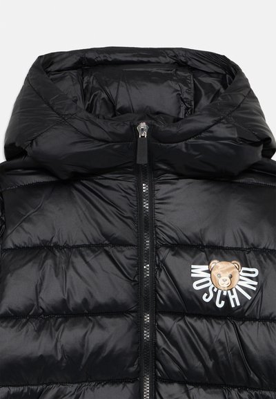 Zwarte pufferjack met een hoge kraag en ritssluiting. Heeft een berenlogo en de tekst "Moschino" aan de voorkant. Gladde, glanzende textuur.