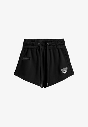 Pantalones cortos negros con cintura elástica, cordones, bolsillos laterales y un pequeño parche con la cara de un osito en la pierna derecha.