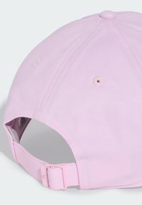 Pink cotton baseball cap with a curved brim, adjustable strap, and ventilation holes; ribbed texture visible on the fabric.