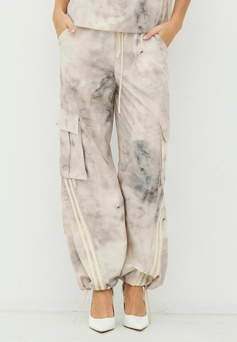 Könnyű, bézs színű batikolt cargo nadrág szürke részletekkel. Oldalzsebekkel, rugalmas mandzsettákkal és függőleges krémszínű csíkokkal az oldalán.
