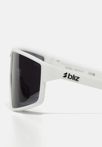 Weiße Kunststoffsonnenbrille mit kantigem Design, dunklen Gläsern und einem schwarzen Logo an den Bügeln, mit mattem Finish und ohne Verzierungen.