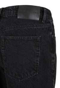 Jeans din denim negru cu un eticheta din piele la talie, cusături închise la culoare și un design clasic cu cinci buzunare, inclusiv buzunare spate înclinate.