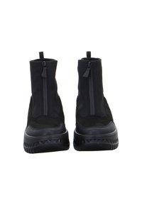 Paar schwarze Knöchelstiefel mit vorderen Reißverschlüssen, dicken strukturierten Sohlen und Zuglaschen auf weißem Hintergrund.