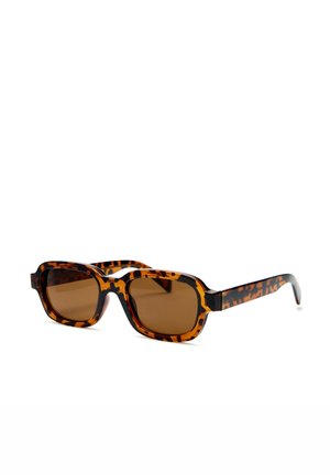 Lunettes de soleil rectangulaires avec de grosses montures écaille de tortue marron et des verres teintés marron sur fond blanc.